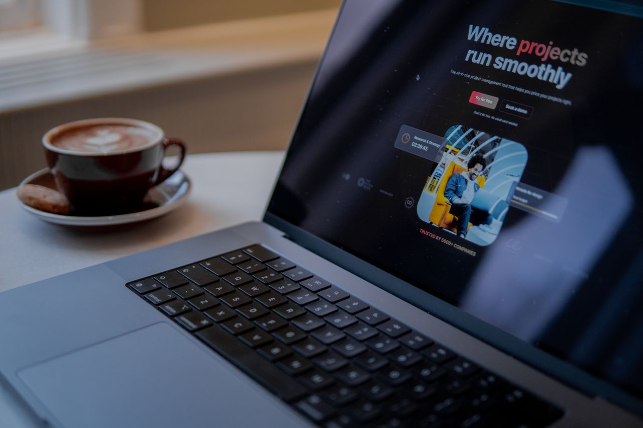 Crafting Captivating Headlines: Your awesome post title goes here A laptop displaying a project management app sits on a table with a cozy cup of cappuccino in Amsterdam.